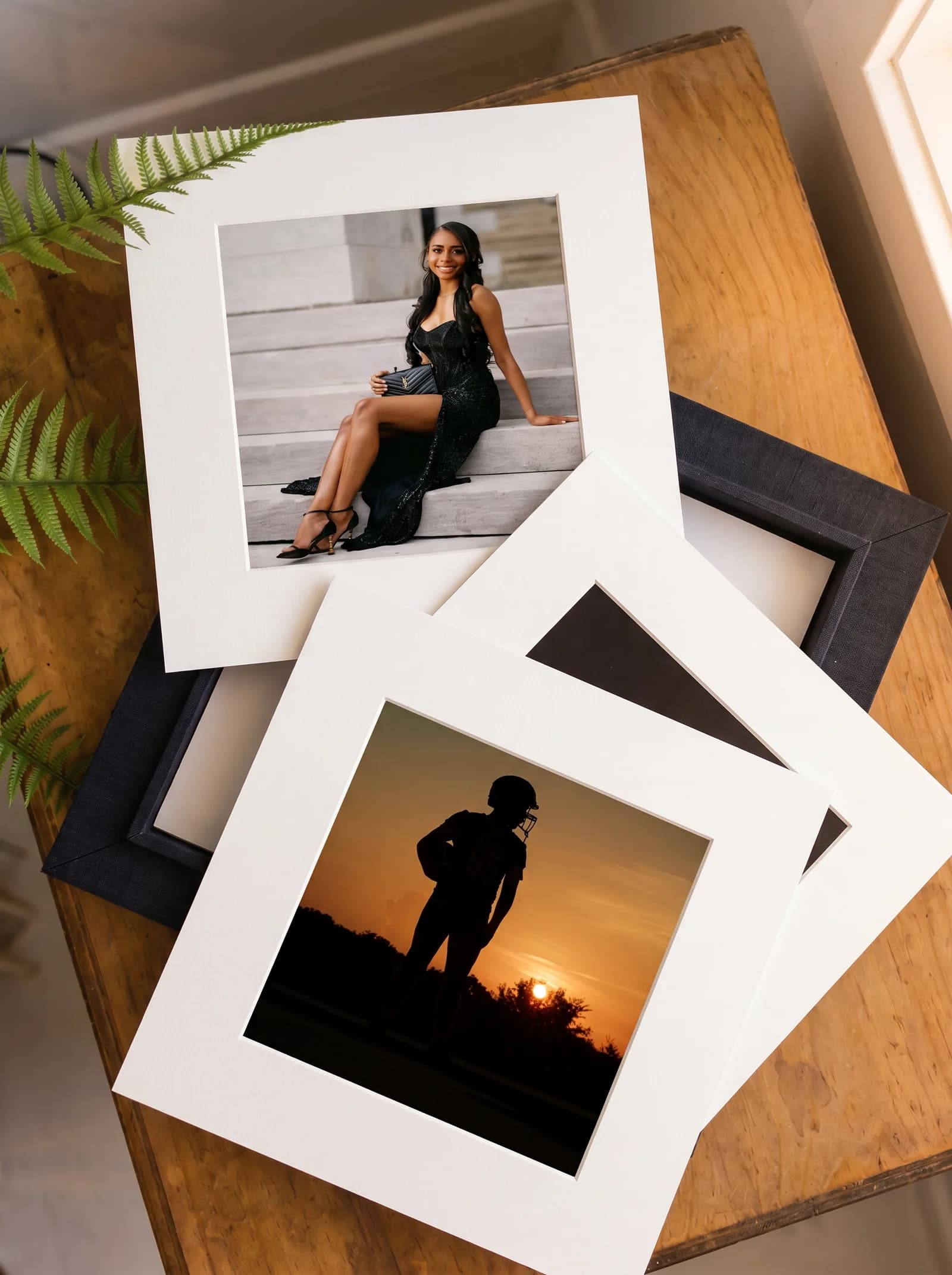 Mockup of matted fine art prints fanned on a wooden table beside a folio box