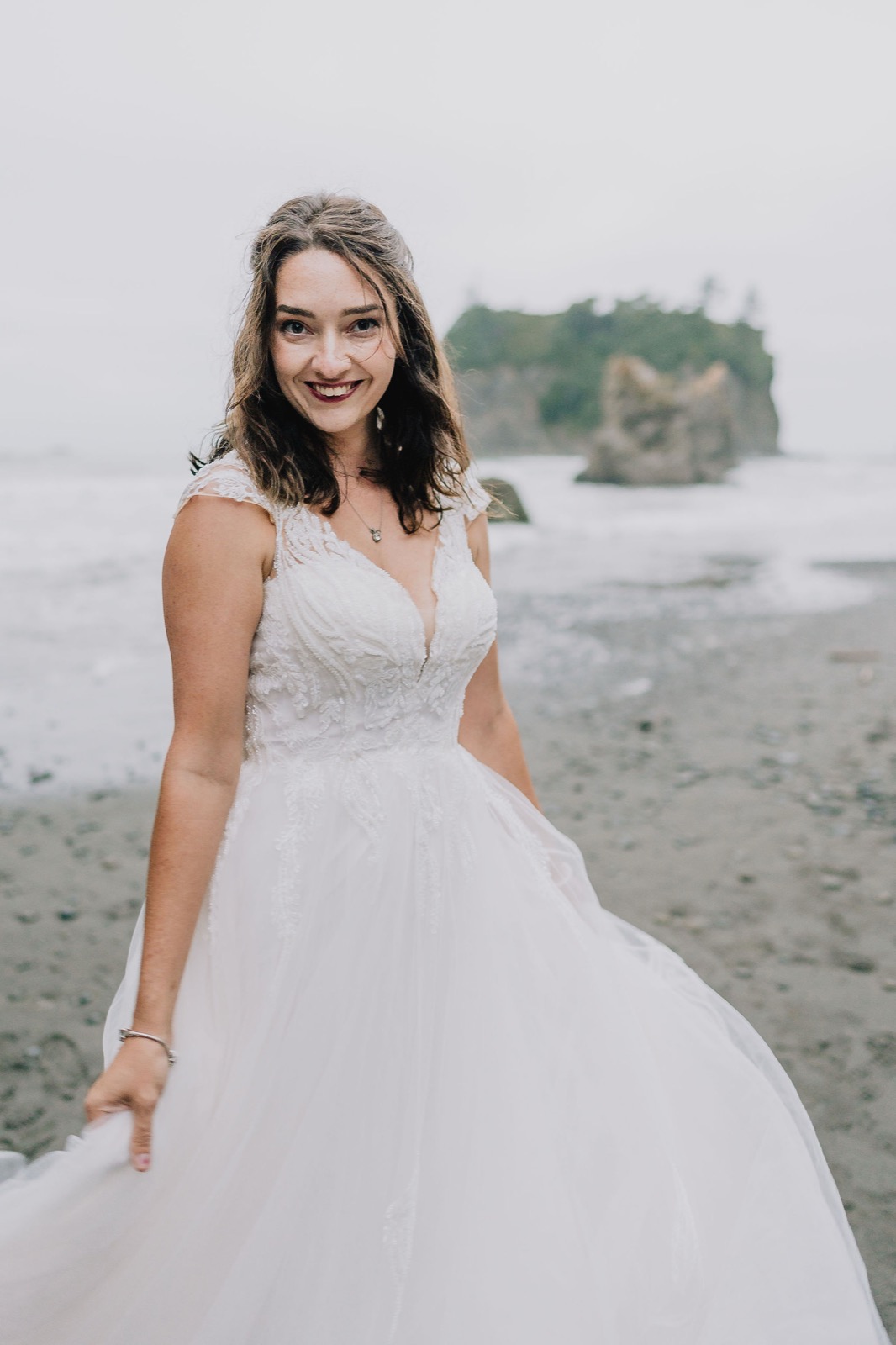 Portrait of the bride on Rialto Beach with Pacific Northwest sea stacks behind her