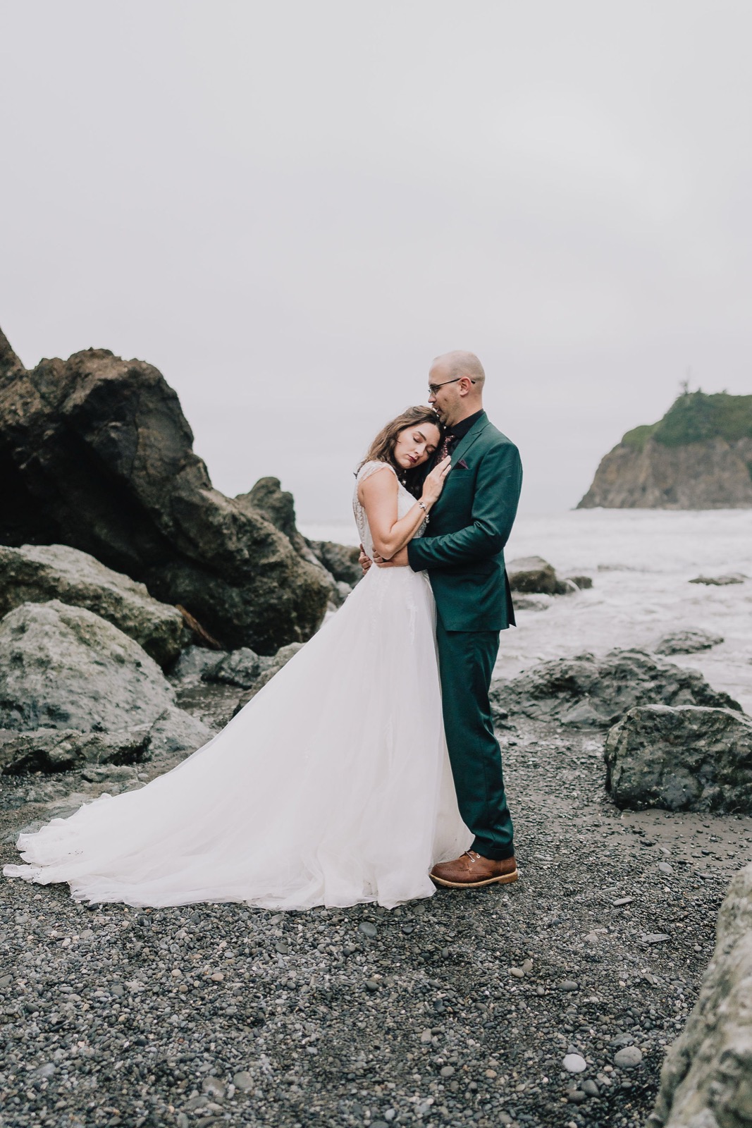 Adriana and Mitchell framed inside a sea stack arch at Rialto Beach during their Washington coast elopement