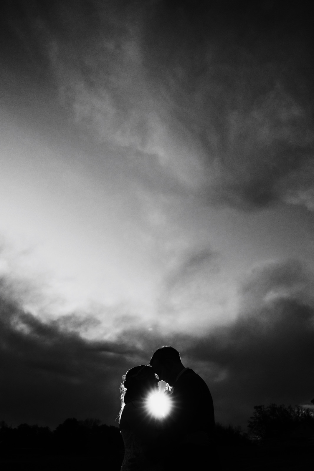 Black and white photograph of a father embracing his daughter in her wedding gown