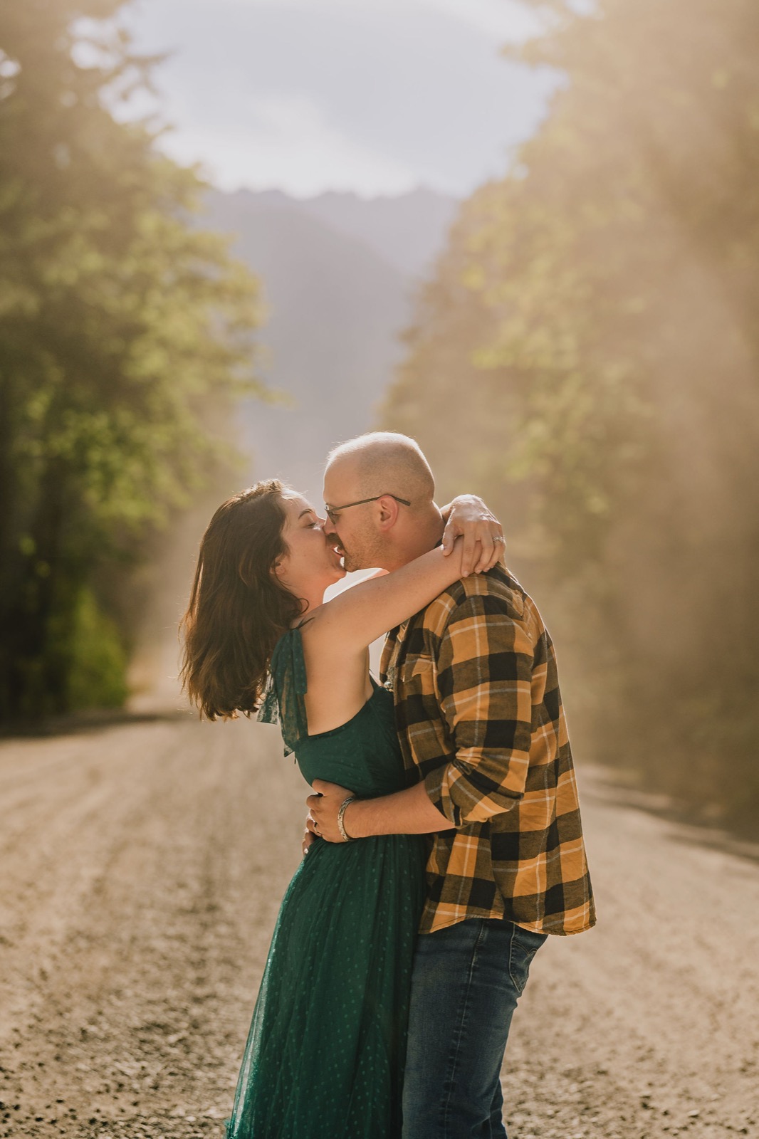 Couple kissing on a fog covered forest road, Olympic National Park elopement